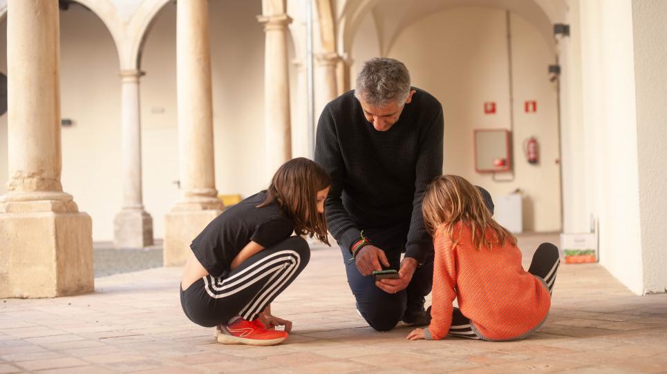L'investigador Josep M. Serra-Grabulosa mostrant NeurekaNUM a dues nenes